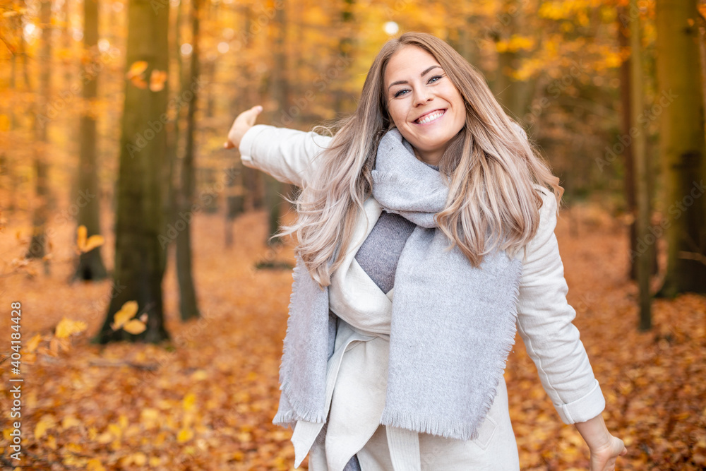 beautyful young women is walking in the park in autumn and enjoys the nature with open arms. beautyful young women is walking in the park in autumn and enjoys the nature with open arms.