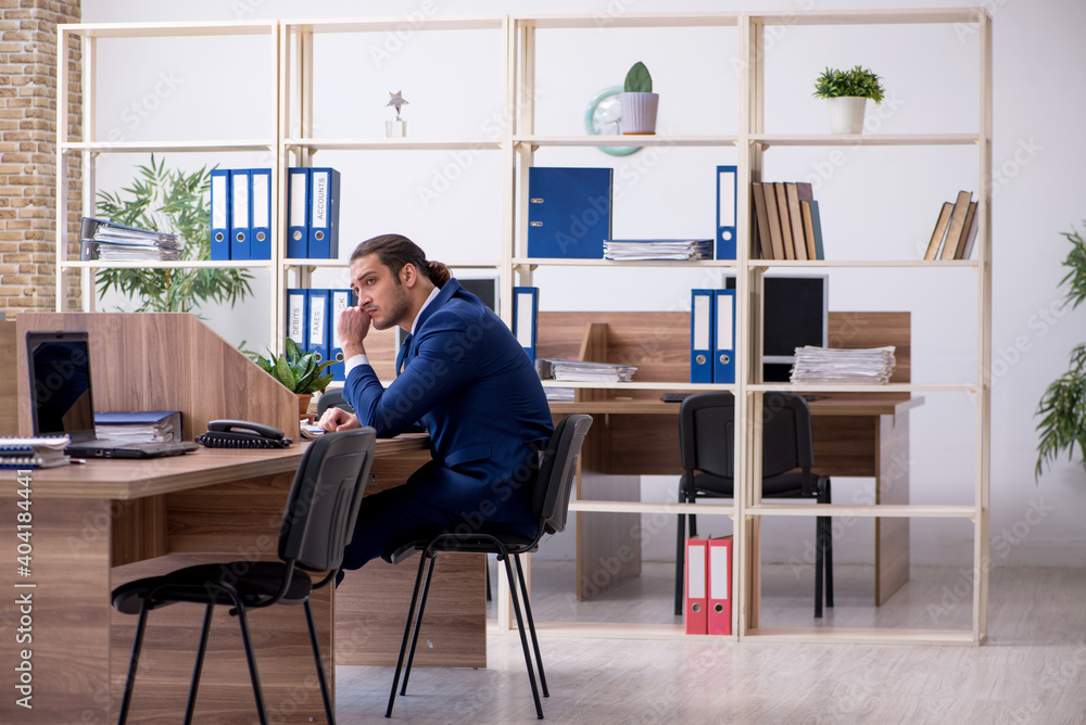 Young male employee working in the office Young male employee working in the office