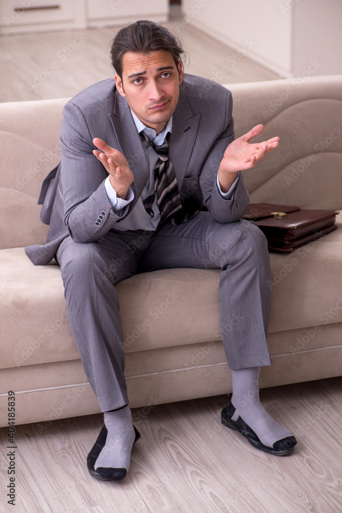 Tired young businessman coming home after working day Tired young businessman coming home after working day