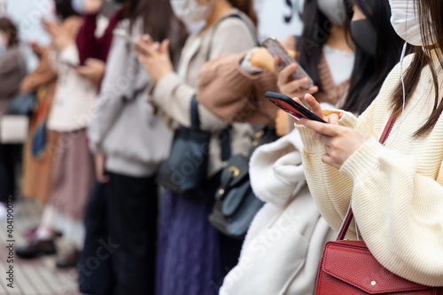 渋谷駅前でスマートフォンを見る若い女性の手元