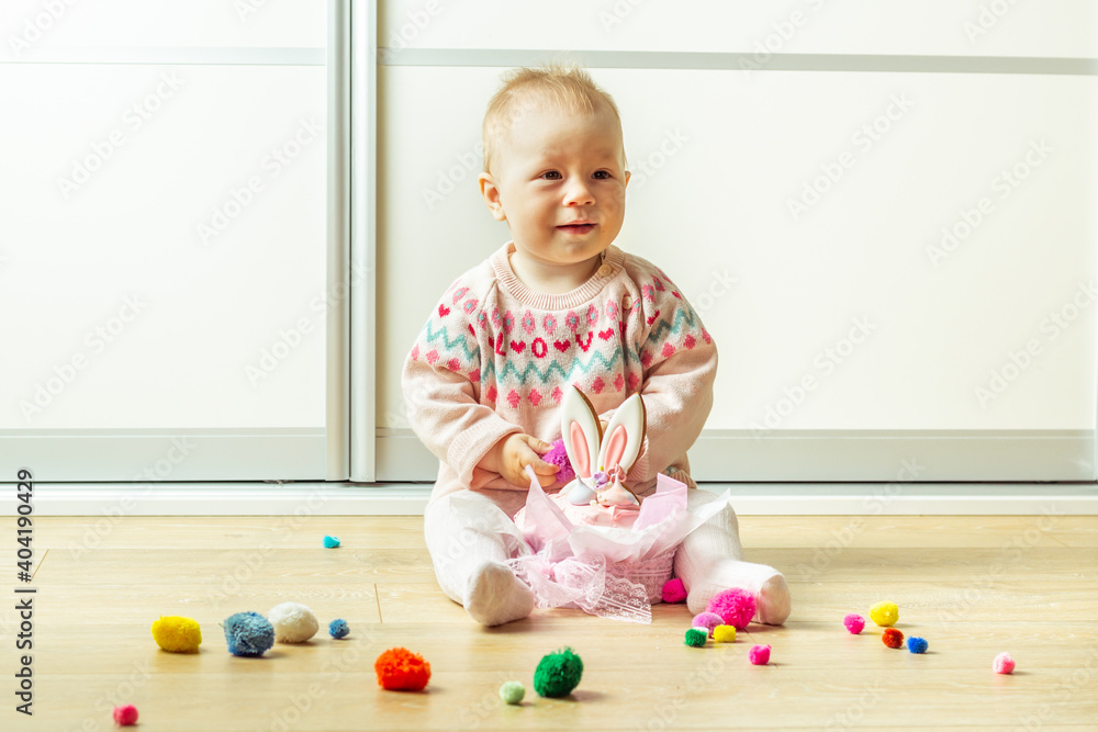 Little baby girl playing with traditional easter bread decorated with bunny ears gingerbread cookies. Creative easter cake decoration. Easter panettone. Happy little kid playing on the floor Little baby girl playing with traditional easter bread decorated with bunny ears gingerbread cookies. Creative easter cake decoration. Easter panettone. Happy little kid playing on the floor