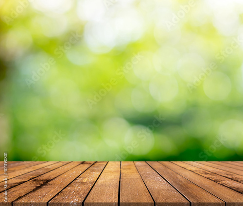 Brown wood surface on green leaf abstract bokeh can be used for displaying product.