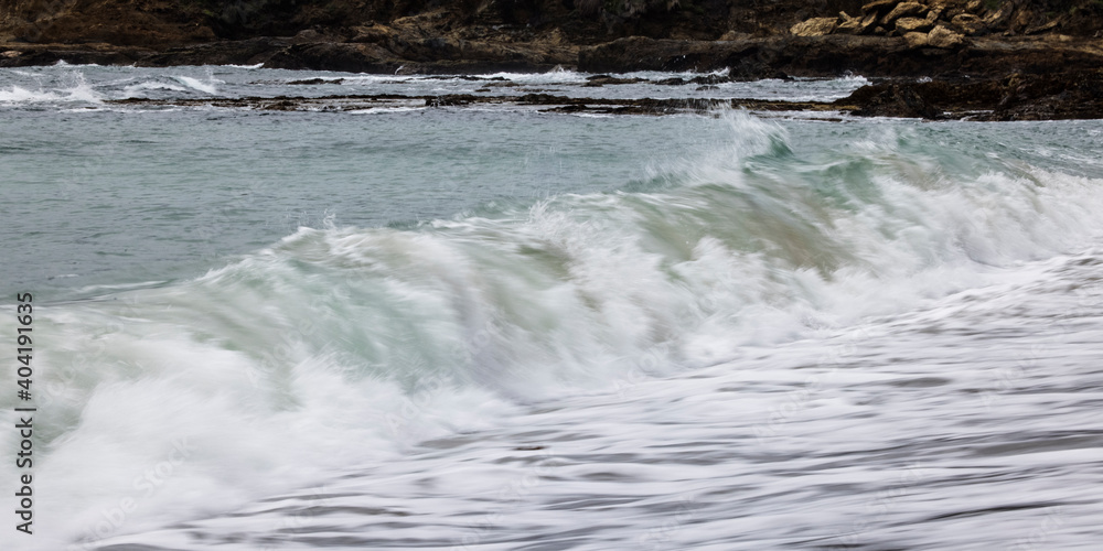 Fototapeta premium Wave Breaking onto sea shore beach