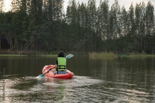 Rear woman kayaking on lake