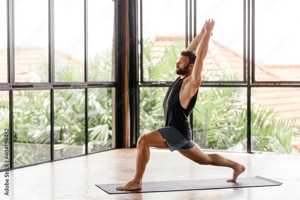 Yoga men workout in studio, training in front of a window Yoga men workout in studio, training in front of a window