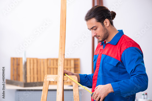 Young male contractor working in workshop