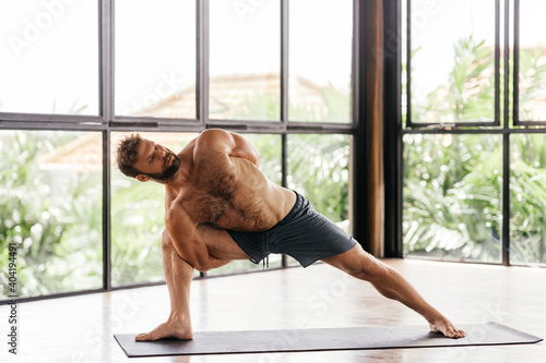 Yoga men workout in studio, training in front of a window