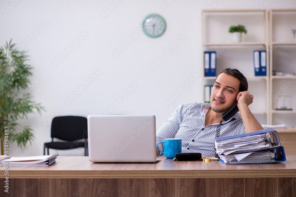 Young male bookkeeper working in the office Young male bookkeeper working in the office