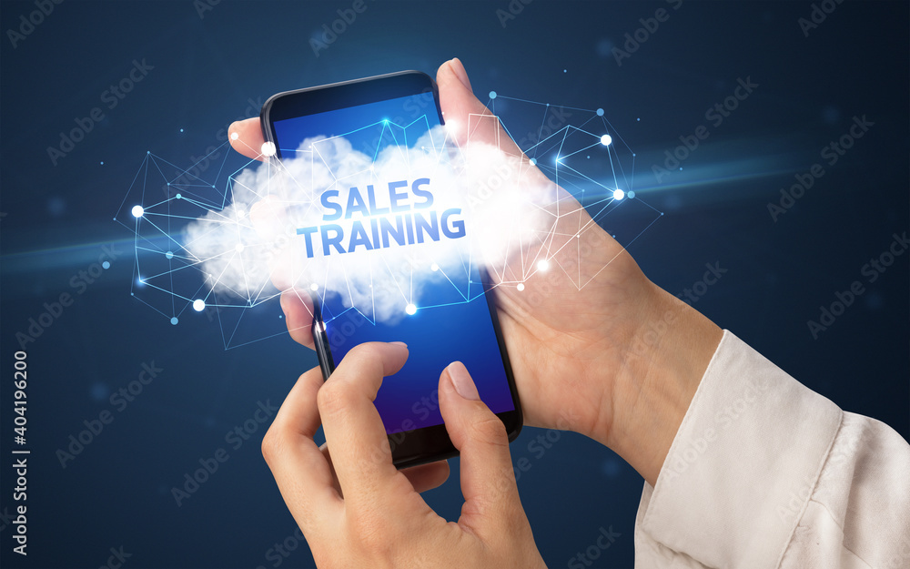 Female hand touching smartphone with SALES TRAINING inscription, cloud business concept Female hand touching smartphone with SALES TRAINING inscription, cloud business concept