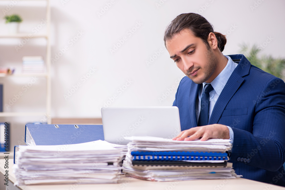 Young male employee unhappy with excessive work Young male employee unhappy with excessive work