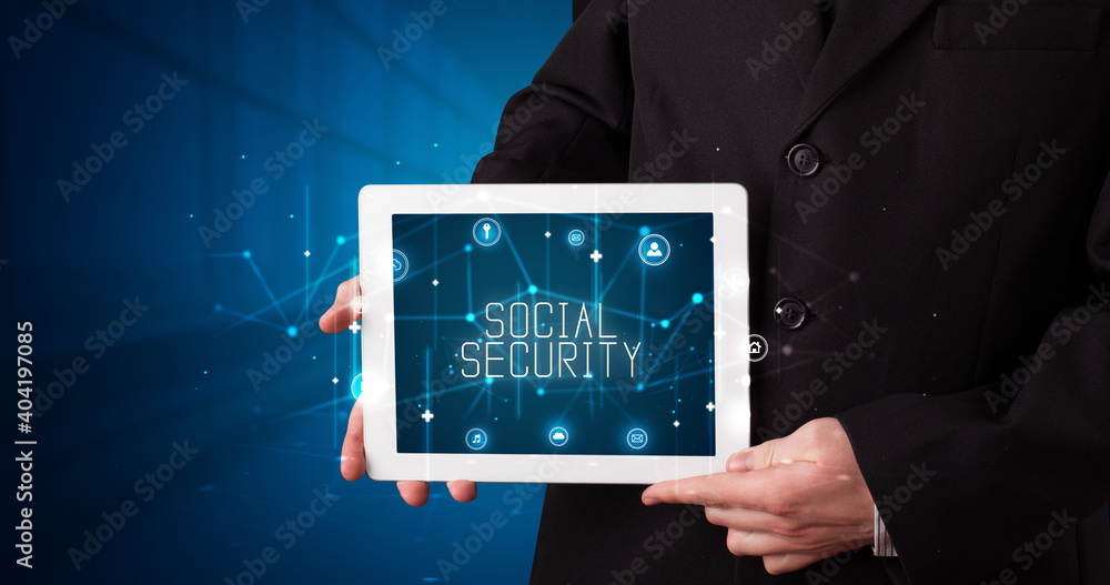 Young business person working on tablet and shows the digital sign: SOCIAL SECURITY Young business person working on tablet and shows the digital sign: SOCIAL SECURITY