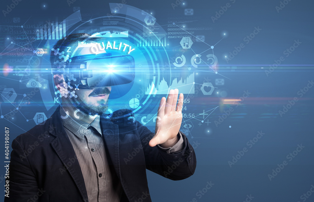 Naklejka premium Businessman looking through Virtual Reality glasses with QUALITY inscription, innovative technology concept