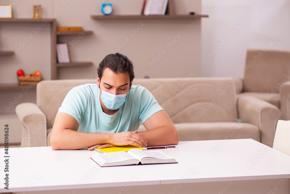 Young male student studying at home during pandemic Young male student studying at home during pandemic