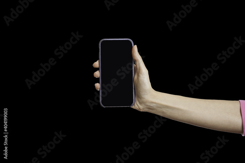 Female hand holding smartphone isolated on black background. Closeup of hand hold mobile phone with clipping path inside photo