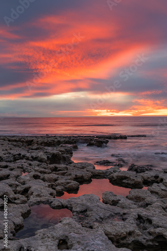 A red sunset reflecting in the rock pools on the Port Willunga beach in  South Australia on January 1st 2021 © Darryl