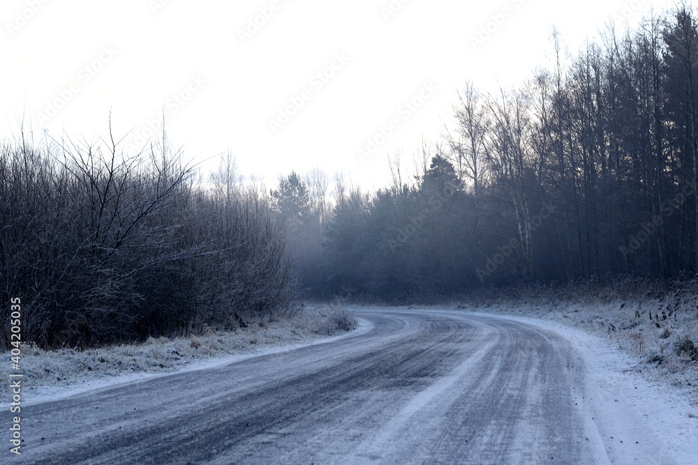 road in ice and snow at wintertime/ danger driving/ winter road at forest