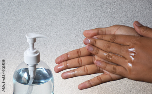 Hands pressing on a sanitizer gel bottle to prevent covid-19