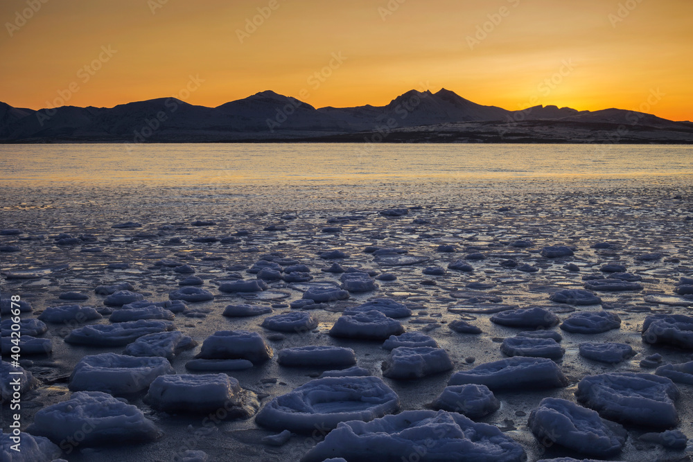 Obraz premium Frozen fjord waters at sunset, Tromso, arctic Norway