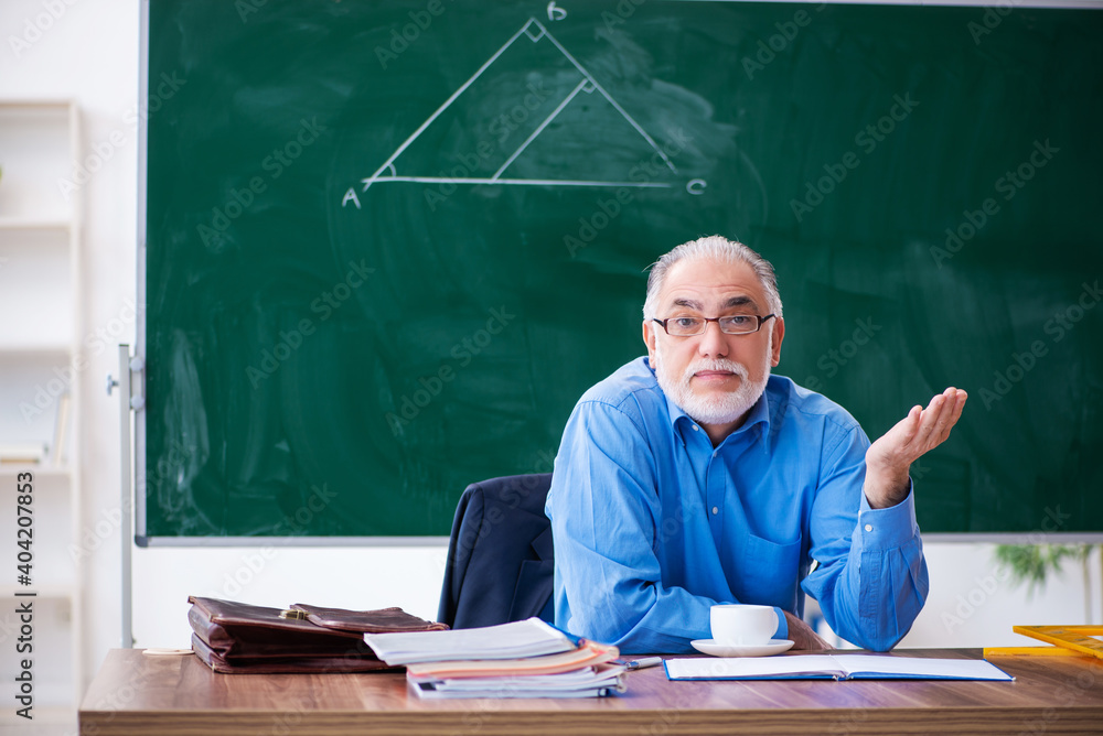 Old male math teacher in the classroom Old male math teacher in the classroom