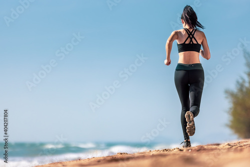 Asian healthy athletic muscle woman running on beach