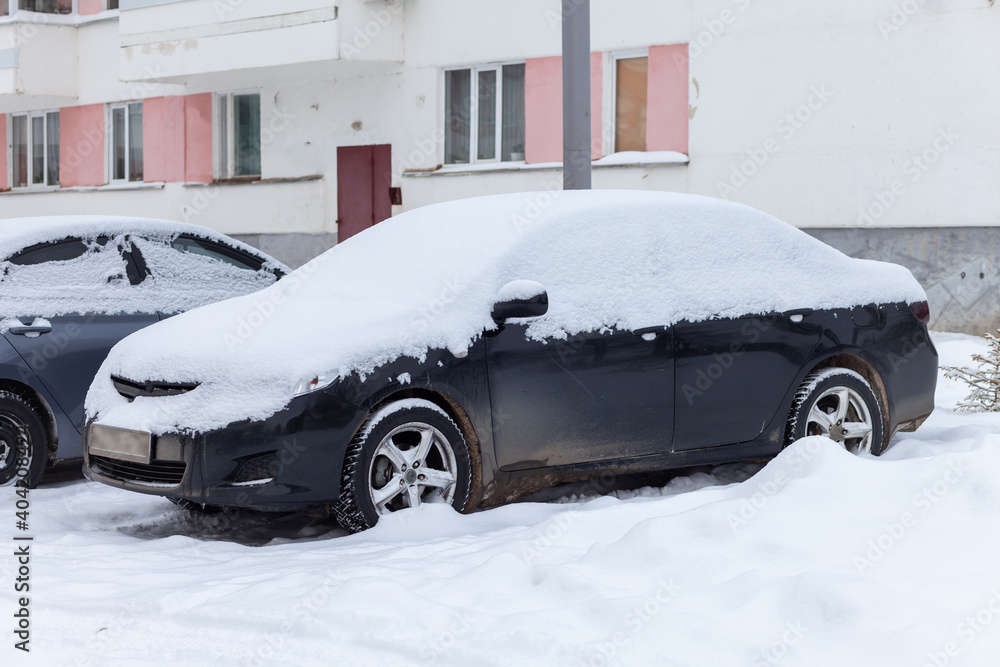 Cars covered with snow after a snowfall.