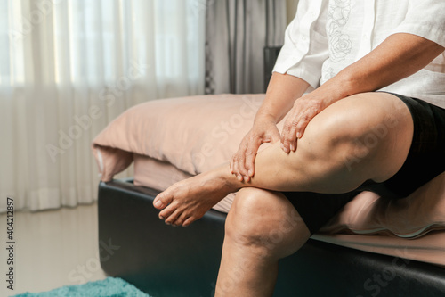 leg cramp, senior woman suffering from leg cramp pain at home, health problem concept