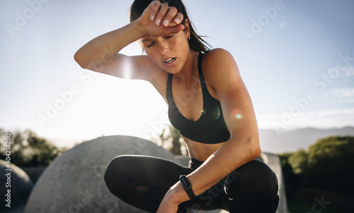 Fotografie Tired woman sitting and resting after workout