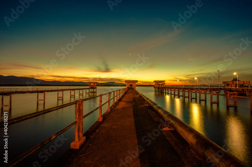The background of the bridge stretches into the sea  with twilight light in the morning  beautiful colors  sky wallpaper and refreshing surroundings.