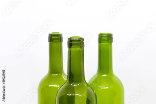 Three green empty wine bottles on a white background