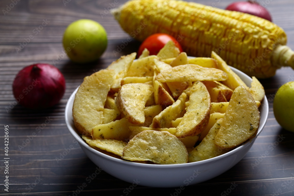 Bowl of crispy baked potato wedges. Bowl of crispy baked potato wedges.