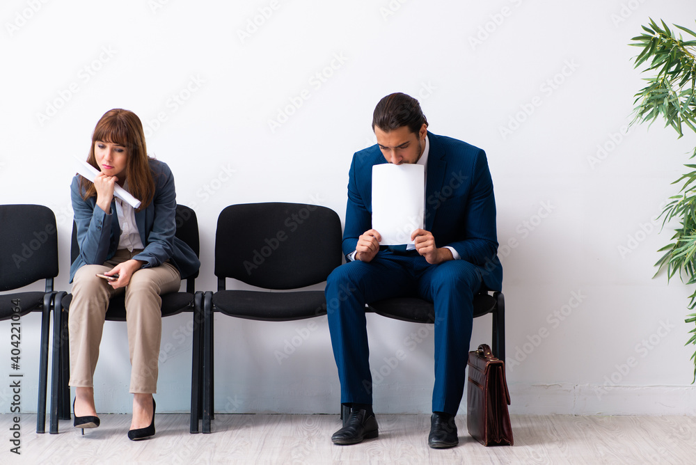 Young businessman and businesswoman waiting for an interview at Young businessman and businesswoman waiting for an interview at