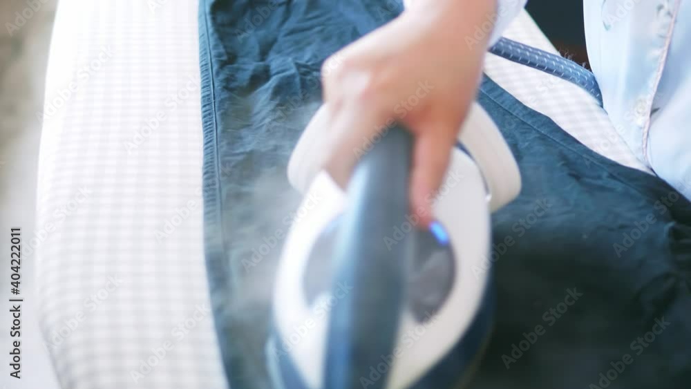 Selective focus of women is ironing clothes and pants to use them throughout the week of work daily routine and holidays. Selective focus of women is ironing clothes and pants to use them throughout the week of work daily routine and holidays.