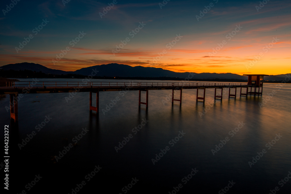 The background of the bridge stretches into the sea, with twilight light in the morning, beautiful colors, sky wallpaper and refreshing surroundings.