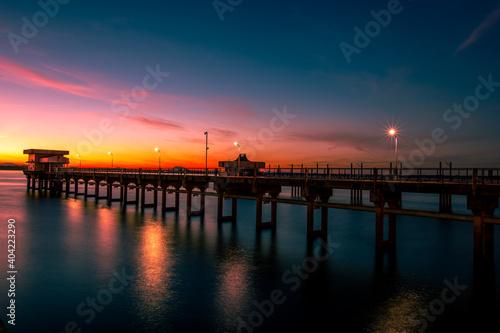 The background of the bridge stretches into the sea, with twilight light in the morning, beautiful colors, sky wallpaper and refreshing surroundings. © bangprik