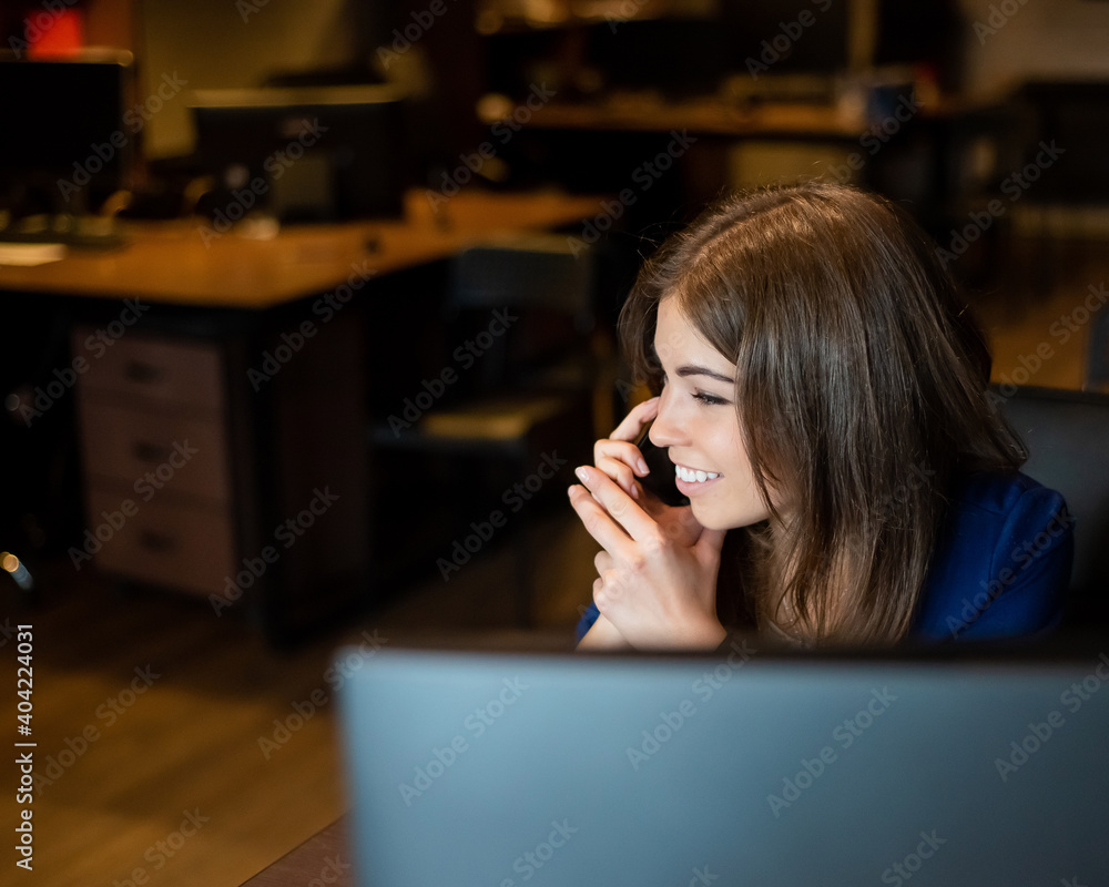 Beautiful caucasian woman talking on a cell phone at a workplace. Portrait of a business woman in the office Beautiful caucasian woman talking on a cell phone at a workplace. Portrait of a business woman in the office
