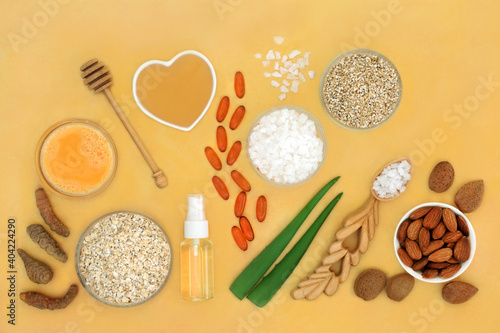 Alternative natural skincare beauty treatment ingredients used to treat skin ailments including eczema, psoriasis, acne, sunburn and skin infections. Flat lay on mottled yellow background.
