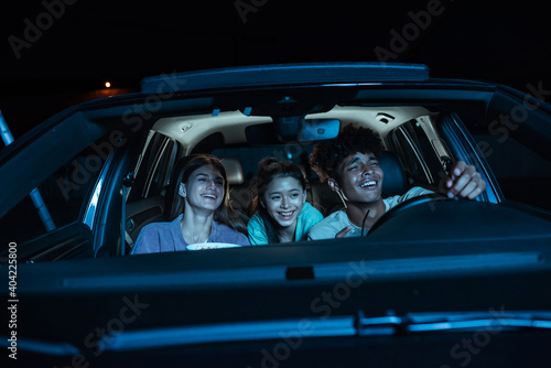Photos Portrait of three young friends looking emotional, laughing while sitting togeth