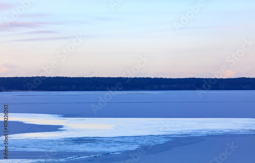 The frozen lake in the rays of the sunset.
