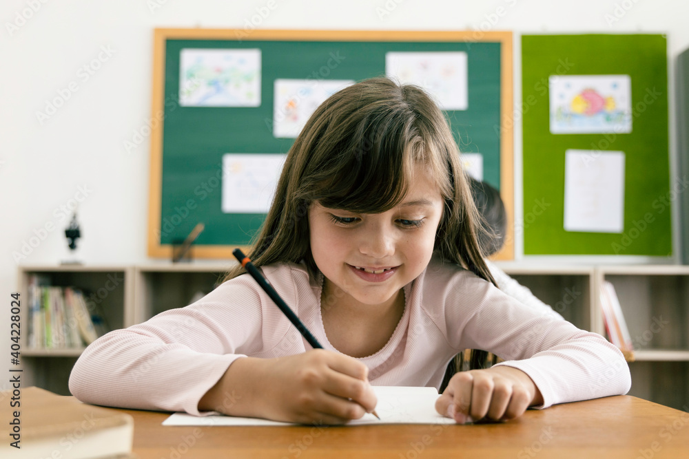 Asian elementary school kids studying in a classroom. The girl smiled Asian elementary school kids studying in a classroom. The girl smiled