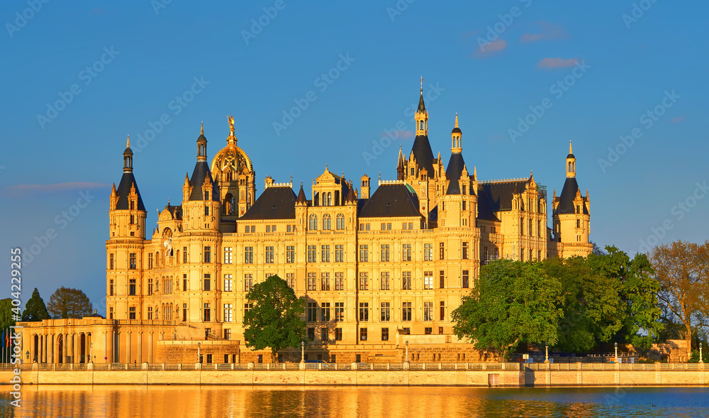 Schwerin Castle with natural golden sunlight and blue sky.
