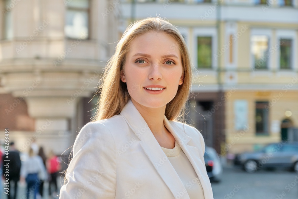Fototapeta premium Outdoor portrait of young successful smiling business woman