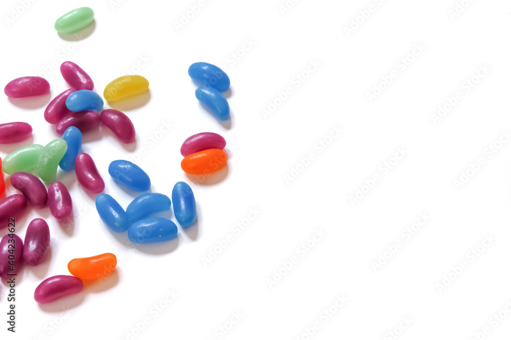 Colored small candies isolated on white background. Unhealthy snacks. Space for text. Colored small candies isolated on white background. Unhealthy snacks. Space for text.
