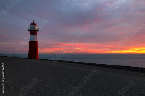 Small lighthouse Westkapelle on the North Sea at sunset, Netherlands