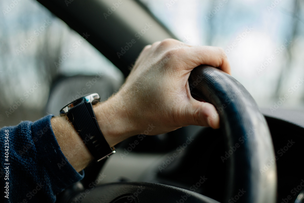 Obraz premium Close-up of a male hand on steering wheel in a modern car in the UK steering wheel on the right