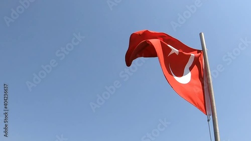 Turkish flag waving on blue sky background. View from bottom. No people, natural colors