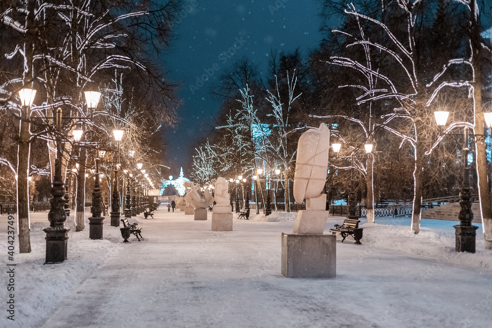 alley with lanterns and sculptures in winter near Ufa Medical University at evening