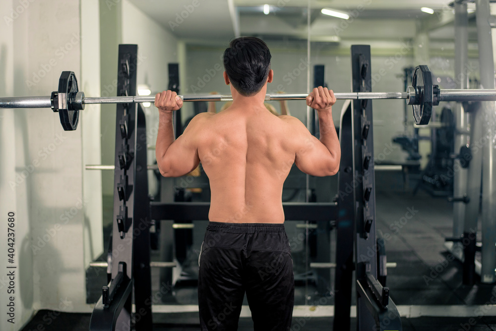Bodybuilder man with big muscular back in the gym Bodybuilder man with big muscular back in the gym