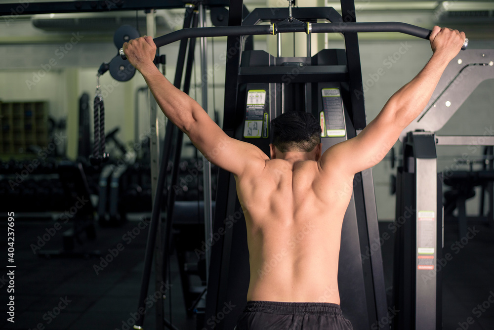 Bodybuilder man with big muscular back in the gym Bodybuilder man with big muscular back in the gym