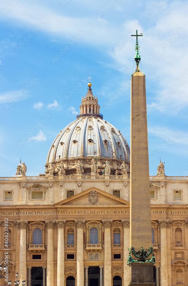 Tall Egyptian obelisk, made of red granite with bronze lions and Chigi arms on the top, in the center of St. Peter's Square, Vatican City. Famous Italian landmark