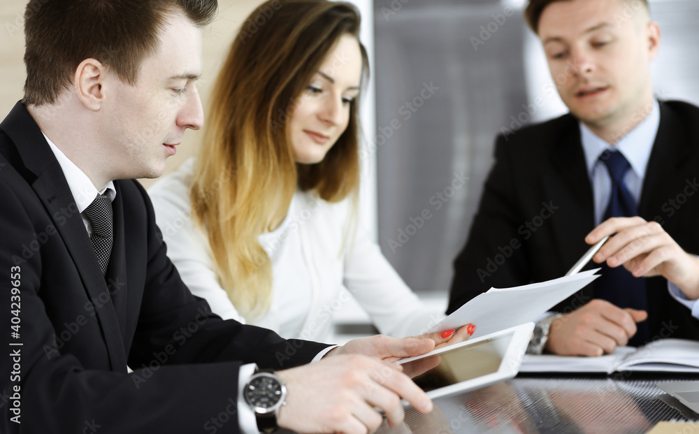 Business people or lawyers discussing questions at meeting in modern office. Unknown businessman and woman with colleague sitting and working at the glass desk. Teamwork and partnership concept Business people or lawyers discussing questions at meeting in modern office. Unknown businessman and woman with colleague sitting and working at the glass desk. Teamwork and partnership concept
